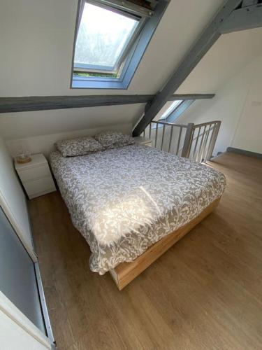 une chambre avec un lit dans un grenier dans l'établissement L’Embrun, à Dieppe