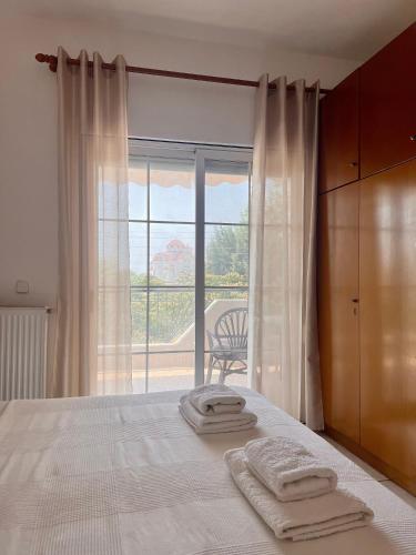1 dormitorio con 1 cama con 2 toallas en Dimitra House Entire apartment with balcony and view, en Pherrai