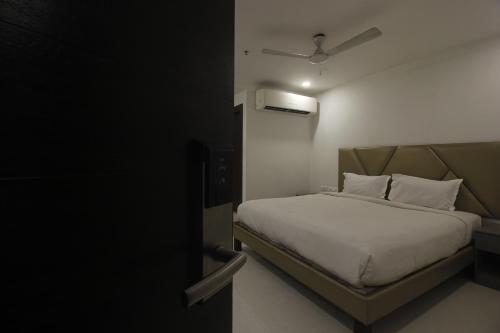 a bedroom with a bed with white sheets and a ceiling at Hotel SSR GRAND in Hyderabad