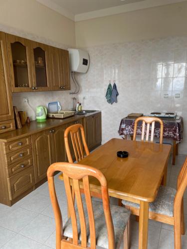 a kitchen with a wooden table and chairs at Lernarot Guest House 