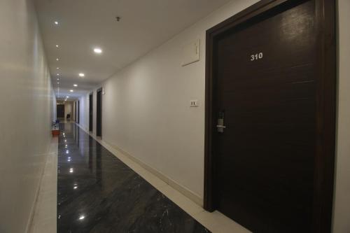 a hallway with a black door in a building at Hotel SSR GRAND in Hyderabad