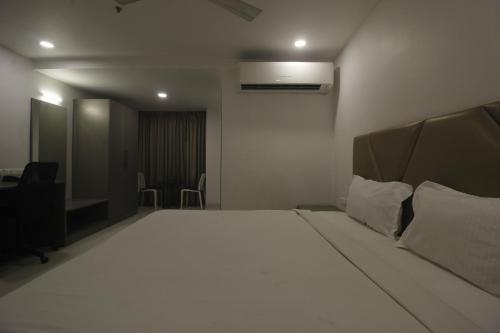 a bedroom with a large white bed in a room at Hotel SSR GRAND in Hyderabad