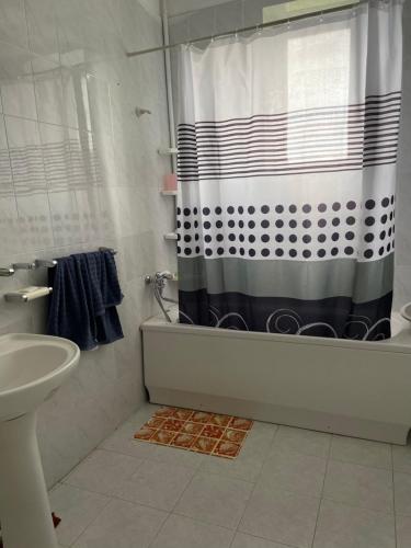 a bathroom with a black and white shower curtain at Lernarot Guest House in Lernarot