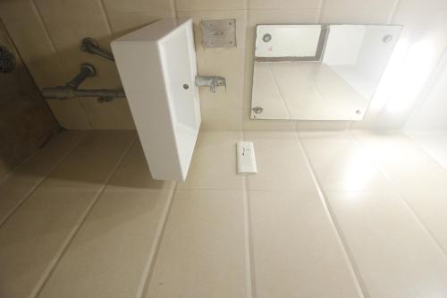 a white bathroom with a urinal and a sink at Hotel SSR GRAND in Hyderabad