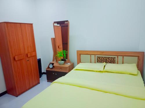 a bedroom with a bed and a wooden cabinet at Kurulu Villa Hikkaduwa in Gonapinuwala West
