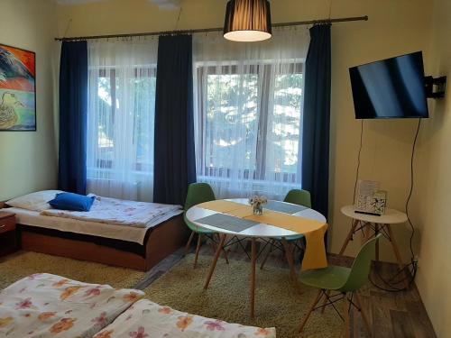 ZbicznoにあるNoclegi Zdzisław Sieradzkiのベッド、テーブル、ベッド、テレビが備わる客室です。