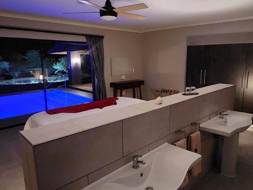 a bathroom with a bed and a sink and a tub at Thandolwami Bushlodge & Spa in Hoedspruit