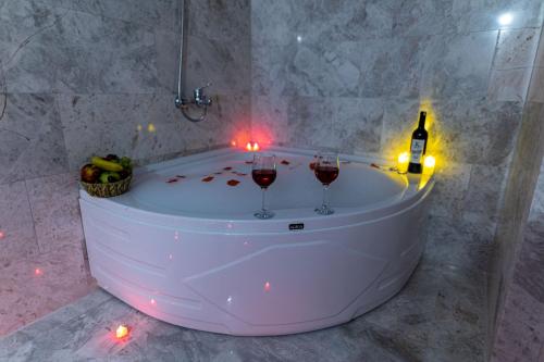 two glasses of wine in a bath tub with candles at Cordial Cappadocia Hotel in Ortahisar