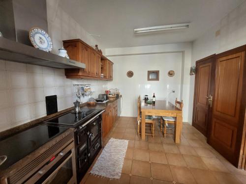 a kitchen with a stove and a table in it at Casa Vily in Vilagarcia de Arousa