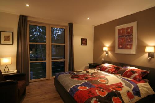 een slaapkamer met een bed en een groot raam bij B&B White Pearl in Müllerthal