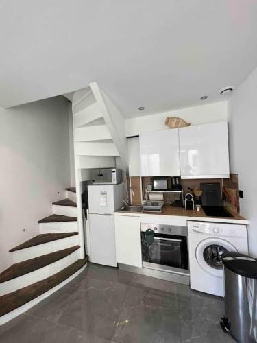 une cuisine avec des placards blancs et un escalier dans l'établissement Maison de pêcheur Bachelet Home, à Trouville-sur-Mer