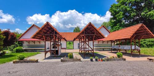 un pavillon avec un toit orange en face d'un bâtiment dans l'établissement Tiny House, à Chvalšiny