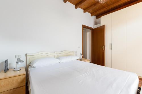 Schlafzimmer mit einem weißen Bett und einem Schreibtisch in der Unterkunft Porta Romana M3- Cosy apartament in Mailand