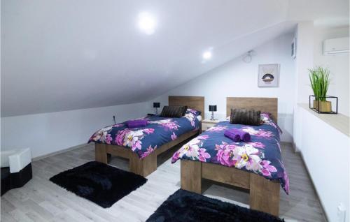 Duas camas num quarto com roupa de cama roxa em 4 Bedroom Lovely Home In Fericanci em FeriÄanci