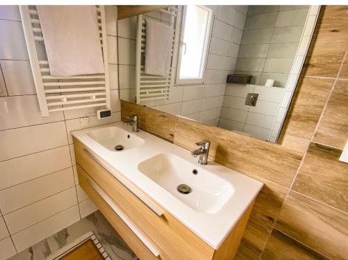 une salle de bain avec un lavabo et un miroir dans l'établissement Maison au calme avec piscine, à Rivière-Saas-et-Gourby