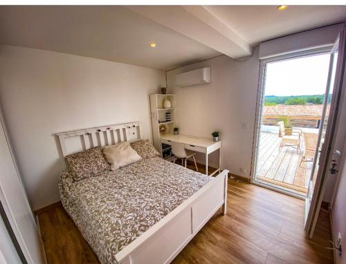 une chambre avec un lit, un bureau et une fenêtre dans l'établissement Maison au calme avec piscine, à Rivière-Saas-et-Gourby