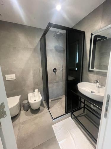 uma casa de banho com um chuveiro, um lavatório e um WC. em Saca Hotel/Apartments em Shëngjin
