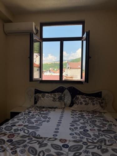 a bedroom with a bed with a view of a window at Center Side in Prizren
