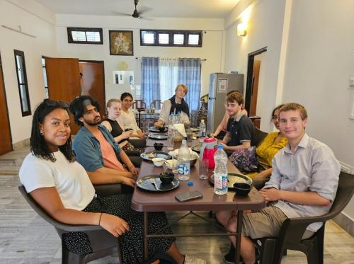 Un groupe de personnes assises autour d'une table dans l'établissement Bhaskar Homestay, à Dibrugarh