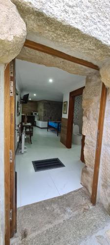 a room with a stone wall and a living room at Solar dos Araújo Coutinho - Casa dos Cavaleiros - Turismo Habitação in Vila da Ponte