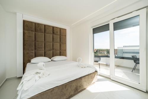 um quarto com uma cama grande e uma janela grande em Apartments Ante em Novalja