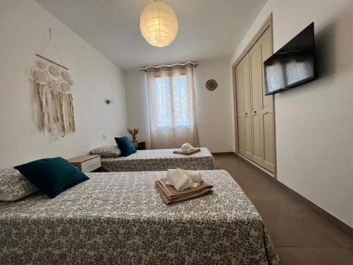 a hotel room with two beds and a television at Maison de village chez Audrey in Ramatuelle