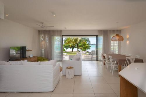 a living room with a white couch and a table at VILLA PIEDS DANS L'EAU - GRAND BAIE in Grand-Baie