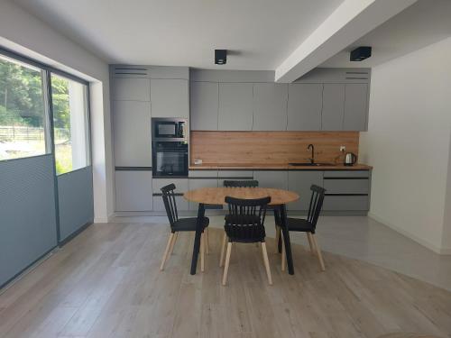 a kitchen with a wooden table and chairs at Apartament na Osiedlu Zielone Zarabie in Myślenice