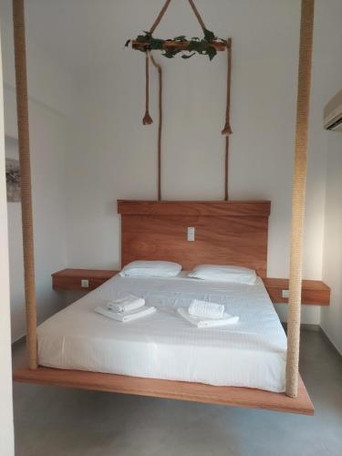 a bed with a wooden frame with two towels on it at Golden Star Praxitelous in Agia Marina Aegina