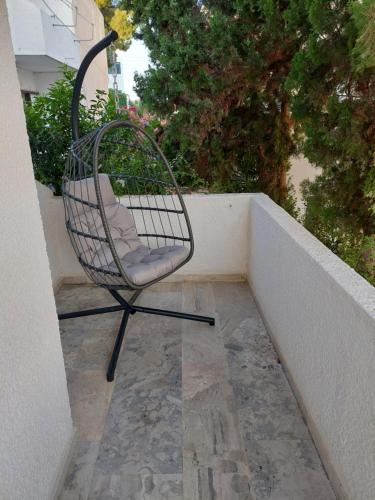 a chair sitting on top of a balcony at Golden Star Praxitelous in Agia Marina Aegina