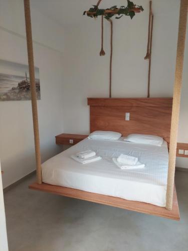 a bedroom with a bed with a wooden frame at Golden Star Praxitelous in Agia Marina Aegina