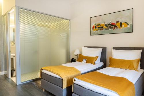 two beds sitting next to each other in a room at The Dome Hotel in Satu Mare