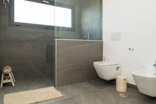 a bathroom with a shower and a toilet and a sink at Villa Alfa by FuerteventuraVillas in Lajares