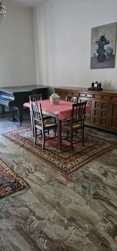 a dining room with a table and chairs and a piano at BELLO E LUMINOSO in Florence