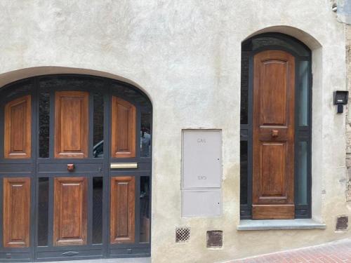 two wooden doors on the side of a building at Contemporary Rooms in San Gimignano
