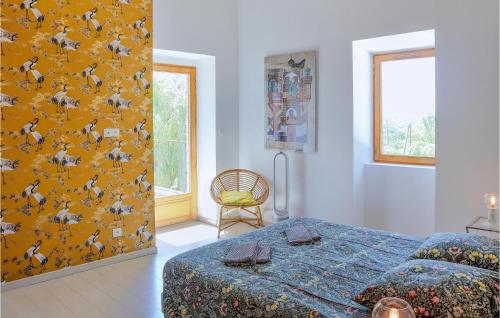 ein Schlafzimmer mit einem Bett und einer gelben Wand in der Unterkunft Lovely Home In St-etienne De Boulogne With Wifi in Saint-Étienne-de-Boulogne