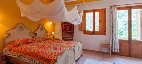 a bedroom with a bed in a room with yellow walls at Can Parròquia in Sant Esteve de Palautordera