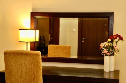 a mirror in a hotel room with a table and two chairs at Hotel Tęczowy Młyn in Kielce