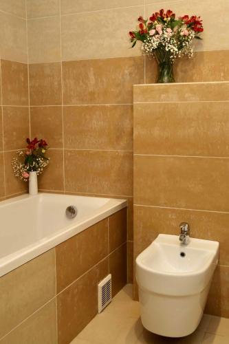 a bathroom with a tub and a toilet and a sink at Hotel Tęczowy Młyn in Kielce