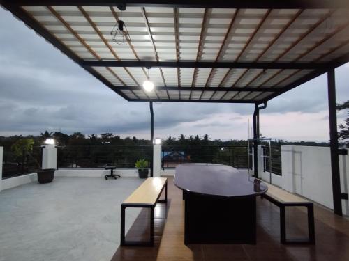 a patio with a table and benches on a roof at Saira Hotel dan Homestay Syariah in Sleman