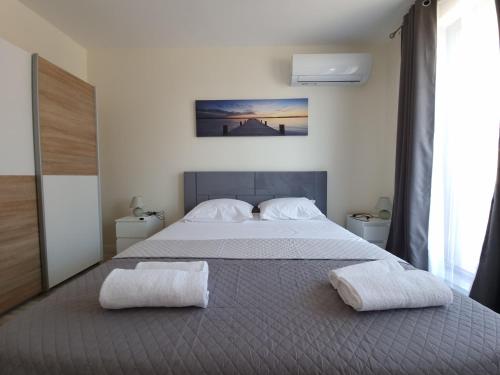 a bedroom with a large bed with two towels on it at Апартаменти Жилищна сграда Орех in Varna City