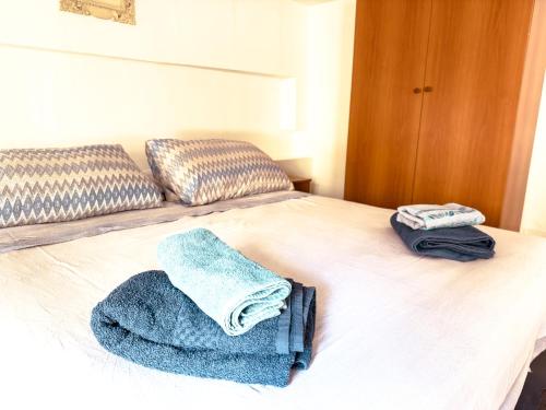 a bed with two towels on top of it at Camurria Apartments in Giardini Naxos