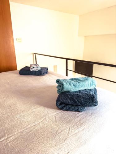 a pair of towels sitting on top of a bed at Camurria Apartments in Giardini Naxos