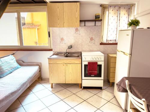 a small kitchen with a sink and a refrigerator at Camurria Apartments in Giardini Naxos