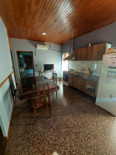 a kitchen with a wooden table and a dining room at HOSTEL DEL HERRERO in Apóstoles