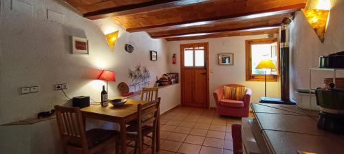 eine Küche und ein Esszimmer mit einem Tisch und Stühlen in der Unterkunft Can Parròquia in Sant Esteve de Palautordera