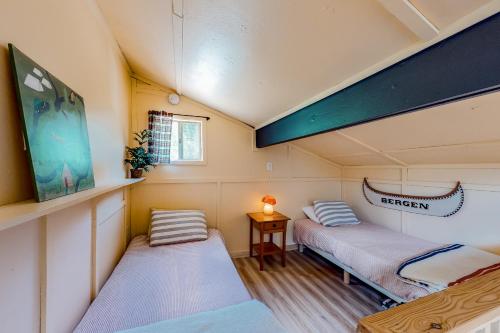 2 Betten in einem kleinen Zimmer mit einem Tisch in der Unterkunft Riverfront Retreat in Cle Elum