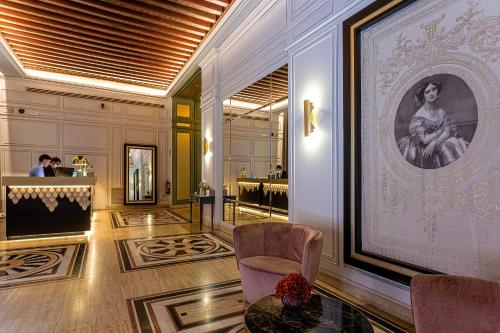 托萊多的住宿－歐仁妮德蒙蒂若傲途格精選酒店，大厅里,有椅子和一张女人的照片