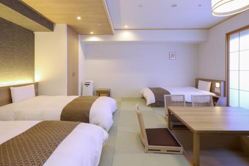 東京にある天然温泉　七宝の湯　ドーミーインPremium銀座のベッド2台とテーブルが備わるホテルルームです。