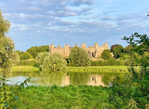 a castle with a lake in front of it at Baytree Cottage Framlingham in Framlingham